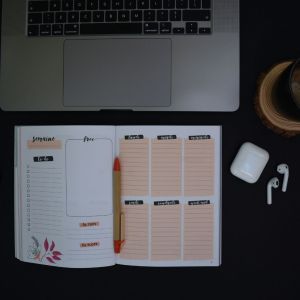 a laptop with a planner opened outside of the laptop