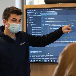 A man at a chalk board teaching others.