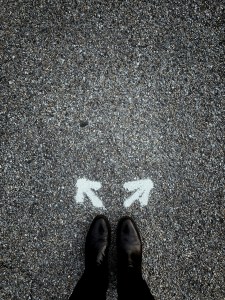 A pair of shoes below chalk drawn arrows pointing in opposite directions.