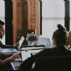 Two people on computers. One seems confused.
